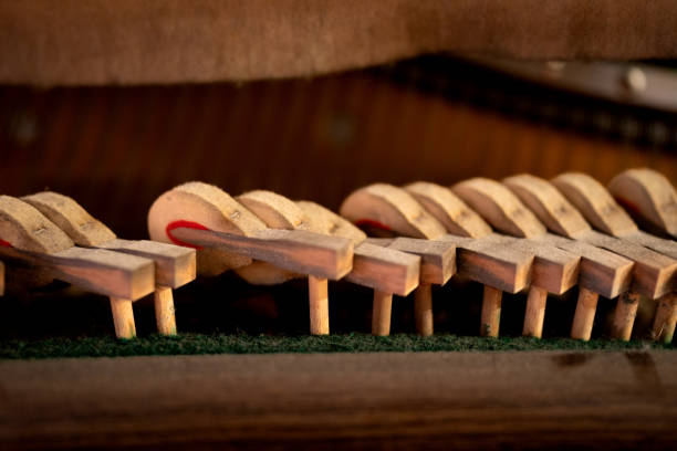 Close-up of old broken dusty piano from the inside. Hammers in abandoned piano striking strings. Music playing from the ancient ruined piano. Gavel of the string open mechanism