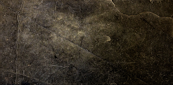 This image shows a floor tile made of natural black stone. Scratches, spots, cracks, mottled shades, spots, speckles and subtle levels of light create a unique impression. Each tile of the entire floor has an unique pattern.  A full frame, close up, high resolution XXL image, shot from above.
