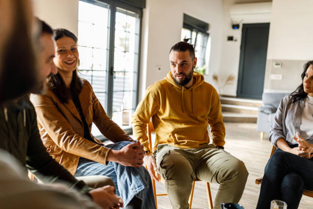 istock Man sharing his life story with people during a group therapy session 1718683438