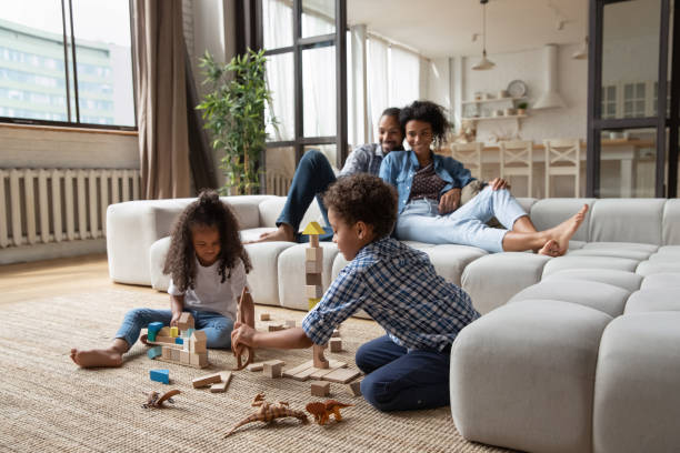 istock Little African American kids playing while parents relaxing on couch 1718703997