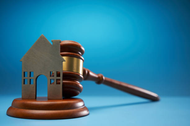 istock gavel hammer and model house against blue background 1718720061