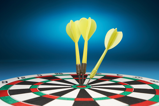 dartboard and arrows on blue background.