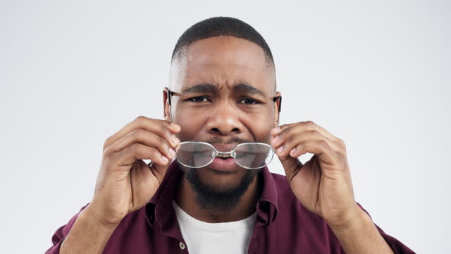 Confused, face and black man in studio with glasses for reading news, promo or info on grey background. Wtf, portrait and African male model with doubt for gossip, drama or coming soon quote offer