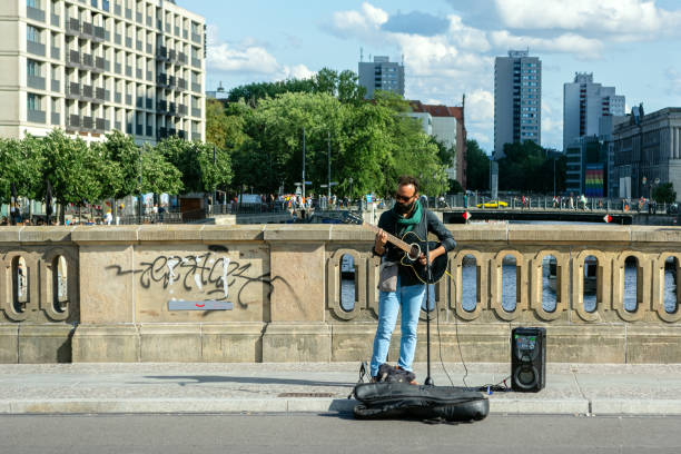 Berlin, Germany, July 20: Street musician guitarist performs his songs on a bridge in Berlin on July 20, 2023.