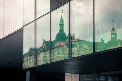 reflection of an ancient building on the windows of a modern building in Copenhagen