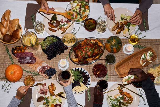 istock Top view people at festive dinner table for Thanksgiving enjoying roasted dishes 1718782458