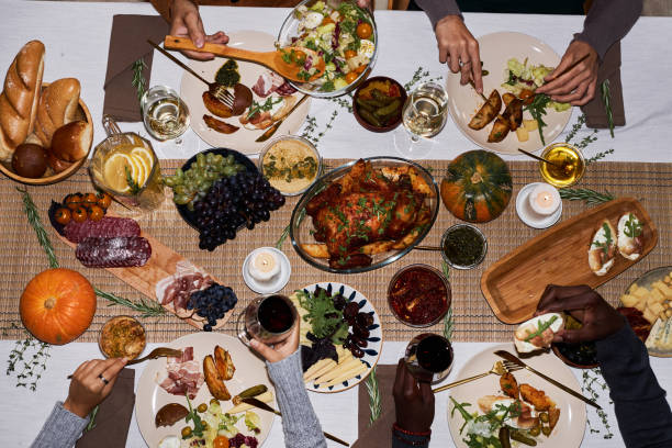 top view people at festive dinner table for thanksgiving enjoying roasted dishes - white meat flash imagens e fotografias de stock