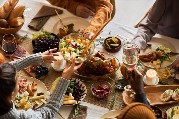 istock Multiethnic group of people at festive dinner table celebrating Thanksgiving 1718782623