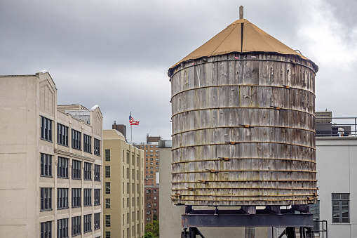West 25th Street, Manhattan, New York, USA - August 17th 2023:  One of the famous wooden water tanks on a roof on a cloudy day