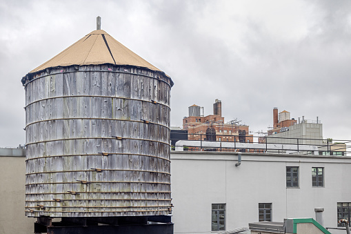 West 25th Street, Manhattan, New York, USA - August 17th 2023:  One of the famous wooden water tanks on a roof on a cloudy day