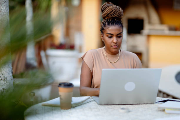 African woman working on laptop from home on her patio