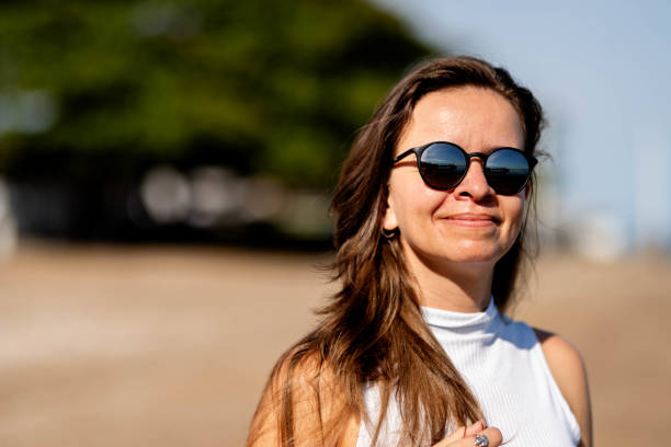 istock Smiling woman wearing sunglasses looking at a scenic beach view 1718802829