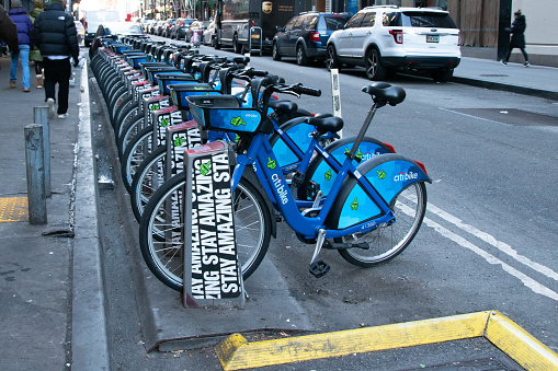 Manhattan, NYC: Public bike-sharing system offers convenient urban transport with rows of available rental bicycles parked on city streets, a popular option for getting around in New York City, USA.