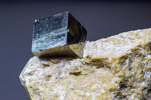 Macro cubical pyrite on white matrix isolated on gray background