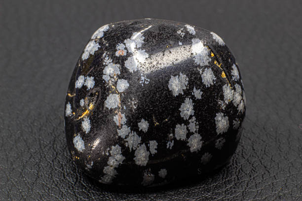 istock Tumbled close up snowflake obsidian isolated on white background 1718807767