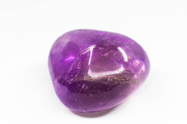 istock Real tumbled Ametrine stone macro isolated on white surface. Purple crystal with a bit of yellow coloration on the end. 1718831713