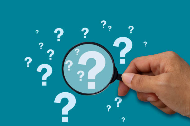 istock Hand holding a magnifying glass with question mark on blue background 1718849436