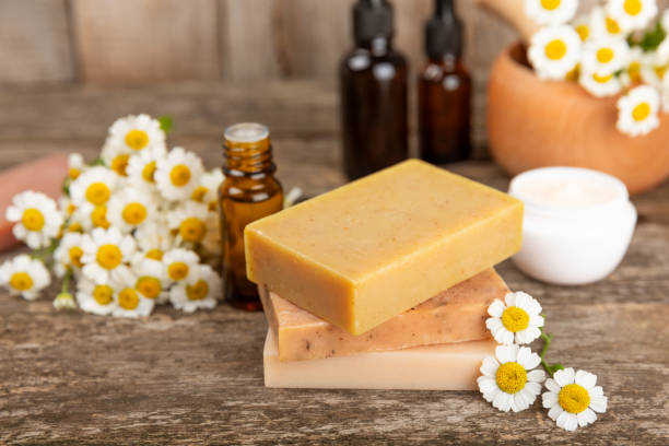 istock Chamomile spa. Composition with chamomile flowers, handmade soap, essential oil cosmetic bottle, body cream, scrub and sea salt on a white texture background. Relaxing beauty treatments.Copy space 1718851648