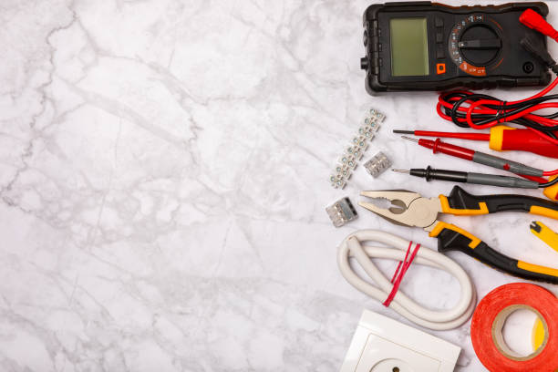 istock Electrician tools on background.Multimeter,construction tape,electrical tape, screwdrivers,pliers,an automatic insulation stripper, socket and LED lamp.Flatley.electrician concept. 1718853334