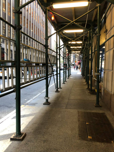 reconstrução da fachada de um edifício de apartamentos histórico em uma rua da cidade, a malha de construção da fachada cobre uma casa antiga fechada para renovação parede exterior - restoring house scaffolding history - fotografias e filmes do acervo