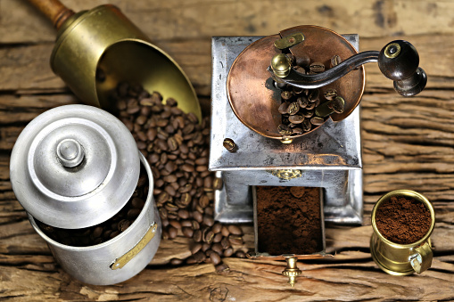 vintage coffee grinder with manufacture roasted Indonesian Arabica coffee beans on rustic wooden background