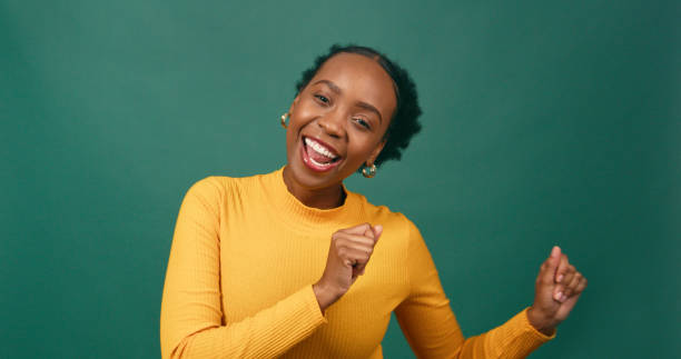 istock Happy young woman dancing, having fun, green studio background 1718873148