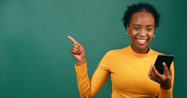 istock Beautiful young woman points to copy space left, excited, sale, green studio 1718887384