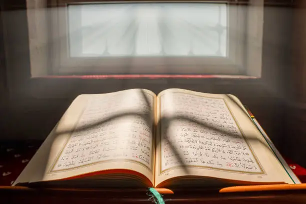 close-up of holy book Quran at mosque , sunlight is reflected to Quran
