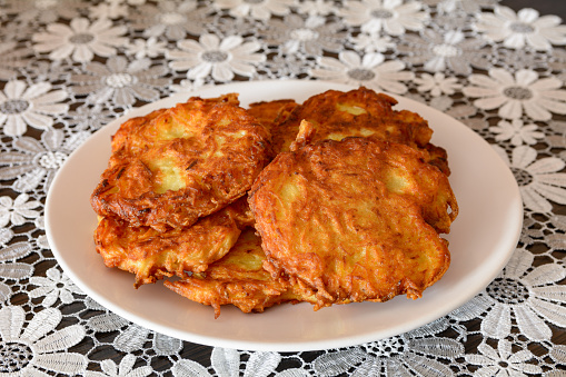Potato latkes served with traditional accompaniments of sour cream, applesauce, and dill. Garnished with dried orange slices.