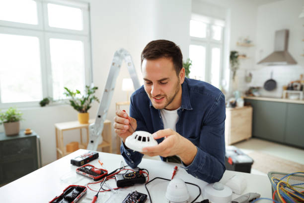 istock Young handsome man installing smoke sensor alarm at home 1718903396