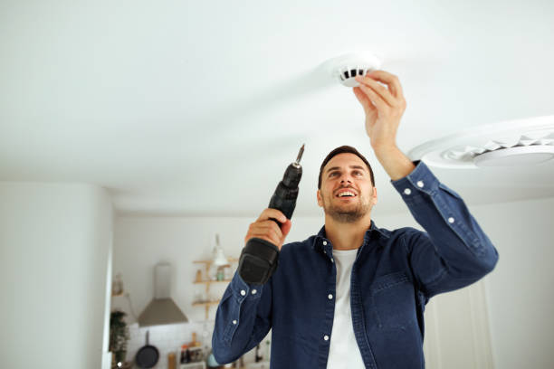 istock Young handsome man installing smoke sensor at his home 1718904490