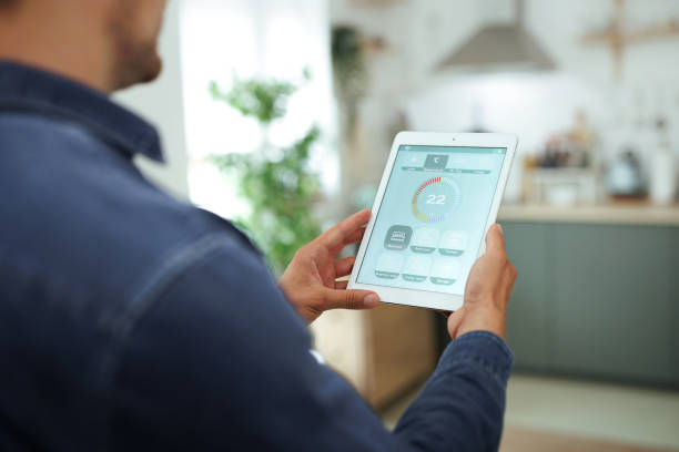 istock Man is Adjusting a temperature using a tablet with smart home app in modern living room 1718905608