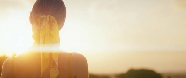 istock Girl watching the sunset on field on a warm summer evening. 1718936457