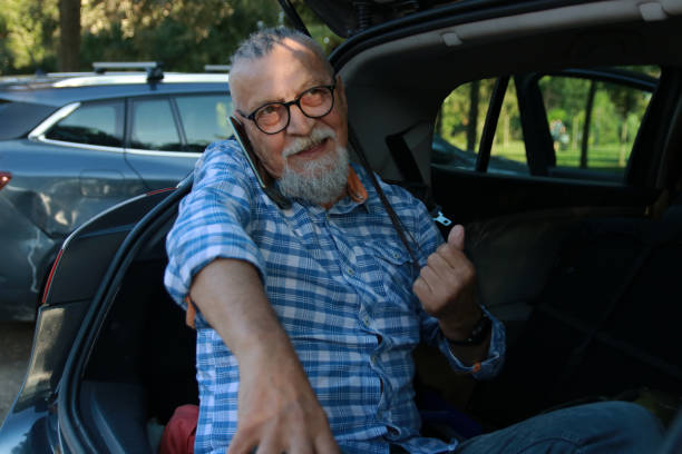 istock Modern senior man talking on phone close car 1718937546
