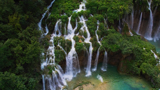 Tropical forest and mountain landscape with streams of water and waterfalls. Cascades flow among lush greenery in spring or summer. Plitvice Lakes National Park Croatia. Travel and nature concept.