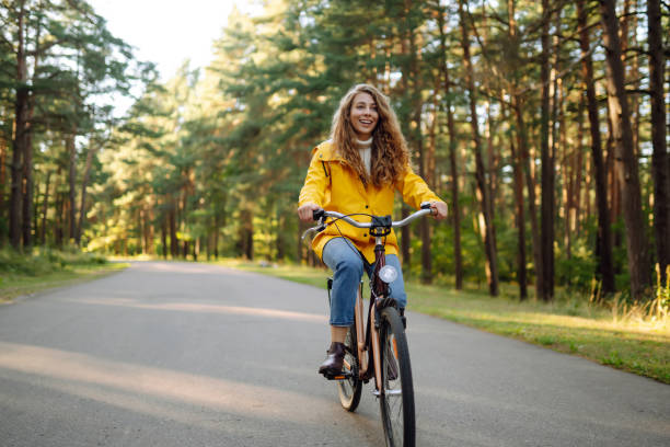istock Smiling woman on a bicycle in an autumn park. 1718944009