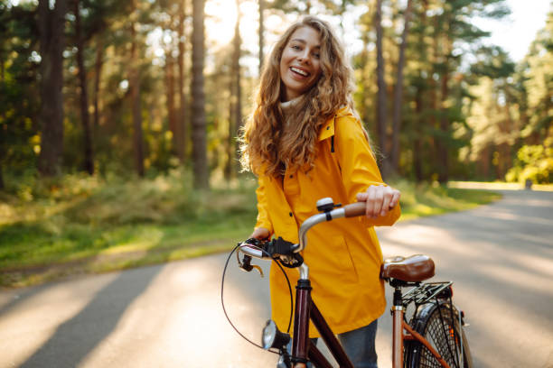 istock Smiling woman on a bicycle in an autumn park. 1718946202