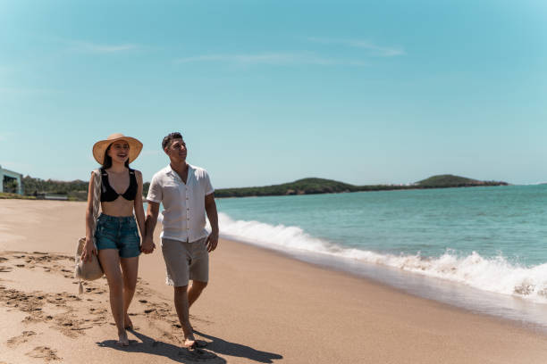 istock Couple walking while talk along the beach 1718947958
