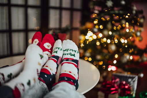 Family wearing christmas socks with their feet on the table at the home