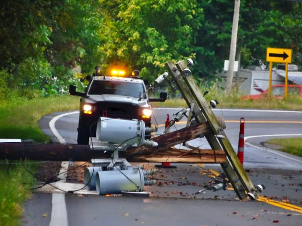 ein weißer rettungswagen mit gelben blinklichtern steht hinter einem umgestürzten strommast, der über eine fahrspur eines state highways im ländlichen ohio gefallen ist. - no passing lane stock-fotos und bilder