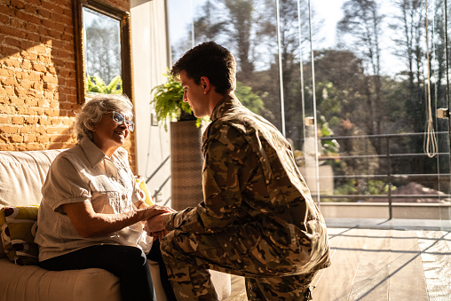 Army soldier talking with his grandmother at home