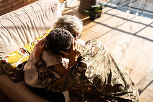Army soldier embracing his grandmother at home