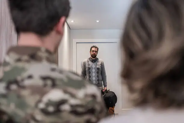 Father holding the bags of his son who was recruited into the army