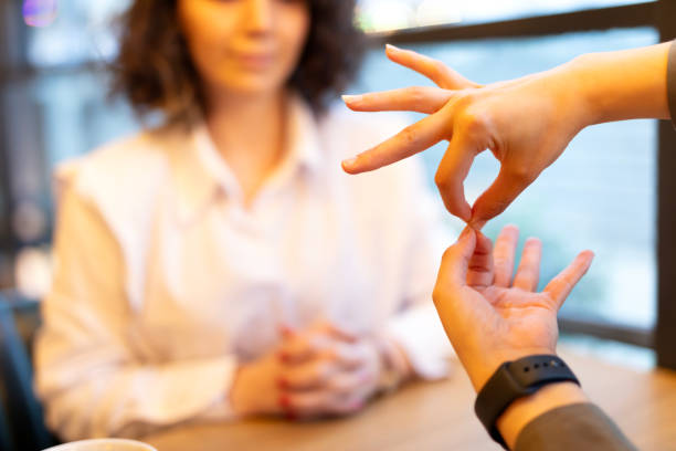 Two young woman speak in sign language