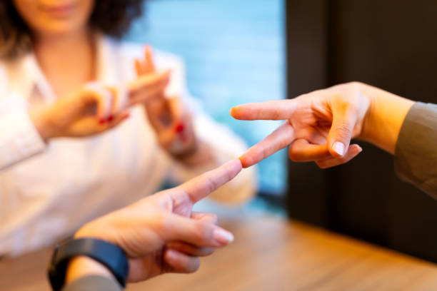 istock Two young woman communicate with sign language 1719045592