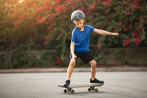Boy learning to ride a skateboard.