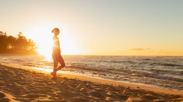 istock Woman at the beach watching beautiful sunset. 1719069336