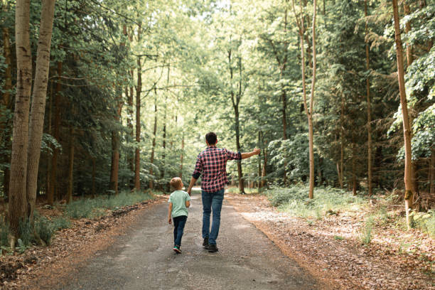 istock Father and son walking through the forest. 1719075869