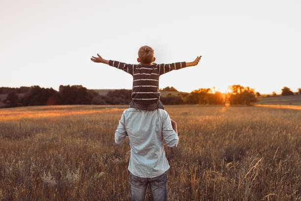 istock Father with child in field enjoying nature in morning sunlight. 1719082580