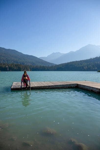 istock Young woman relaxes on lakeside dock in the morning 1719084221